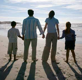 Photograph of a family looking towards the ocean at sunset